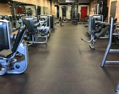 Selectorised weight machines beside a mirrored wall.